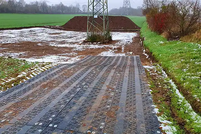 Mobile Baustraßen aus den Fahrplatten und Lastverteilungsplatten von TERRAGUIDE Mobile Baustraße zur Baustelle über schützendswerte Grünflächen